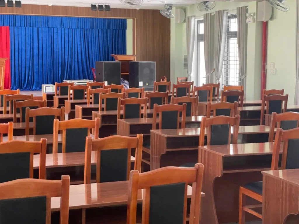 Hội trường trường học quận Thanh Khê với ghế đỏ và bục phát biểu gỗ