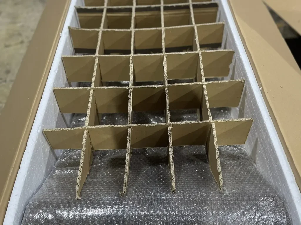 Kartonteiler über einem verpackten Bett im langen Exportkarton.